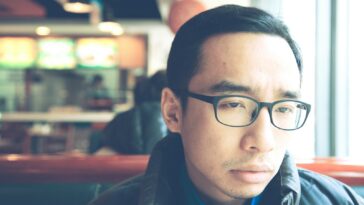 man in black framed eyeglasses and black jacket