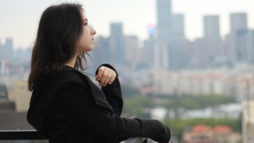 woman in black long sleeve shirt looking at the city during daytime