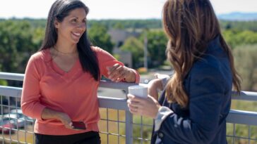 2 women standing beside railings during daytime