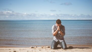 man kneeling down near shore