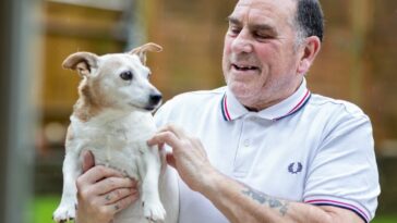 a man holding a small dog in his hands