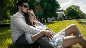 man and woman sitting on green grass field during daytime