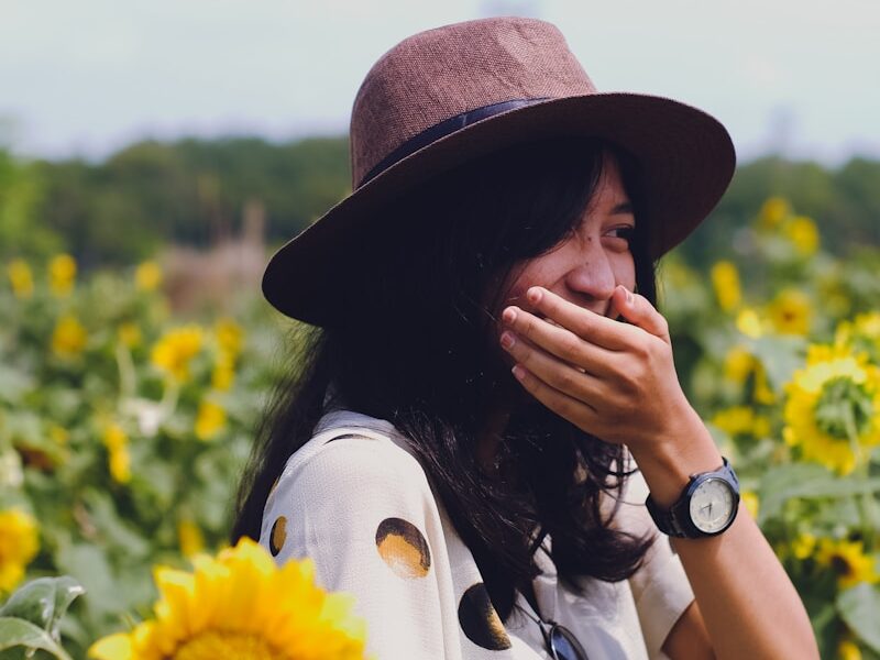 selective focus photography of woman between sunflowers