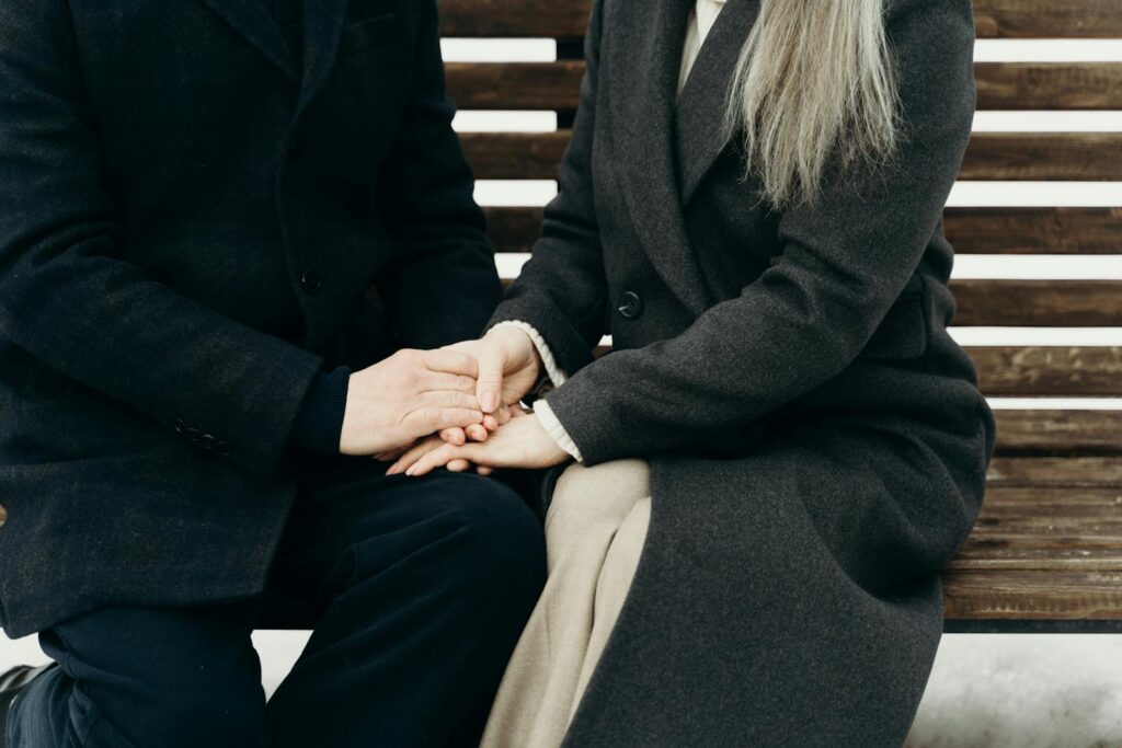 An intimate moment between a couple seated on a bench sharing warmth and affection.