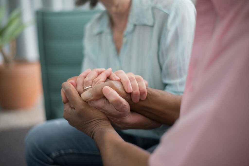 A close-up of a senior couple's hands interlocked in a comforting and loving embrace, symbolizing connection and support.