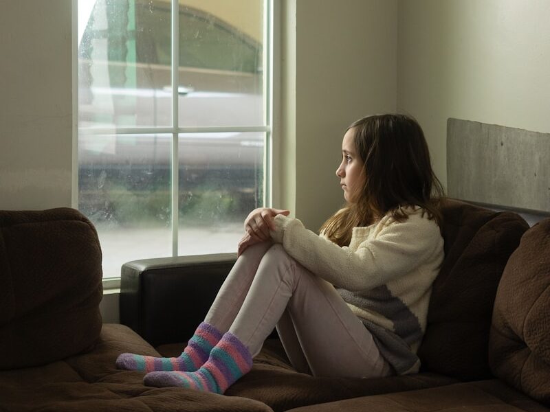 woman in white long sleeve shirt sitting on black couch