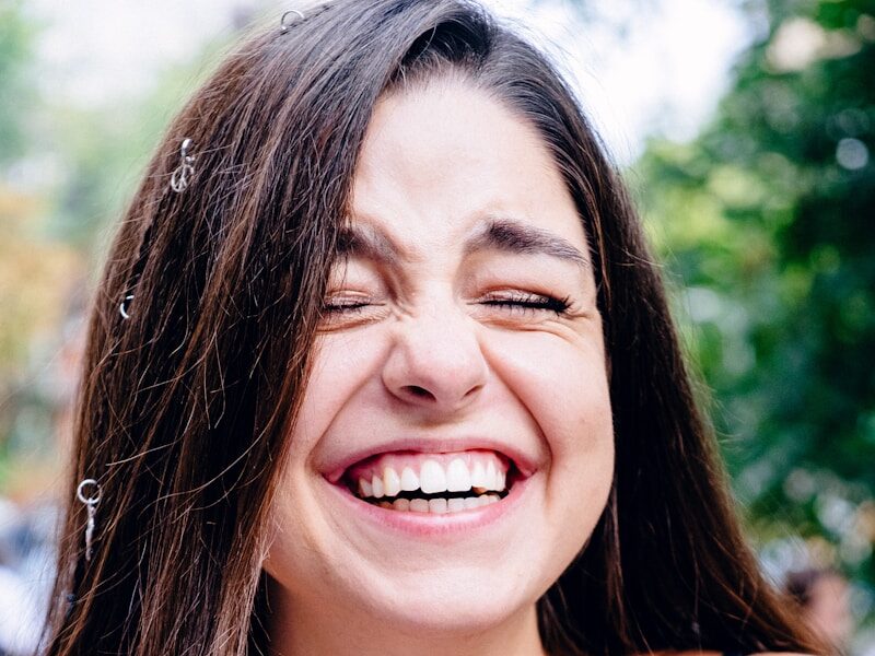 woman in black spaghetti strap top smiling
