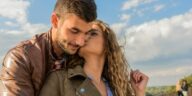A loving couple embraces under a clear sky, showcasing romance and togetherness.