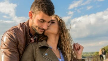 A loving couple embraces under a clear sky, showcasing romance and togetherness.