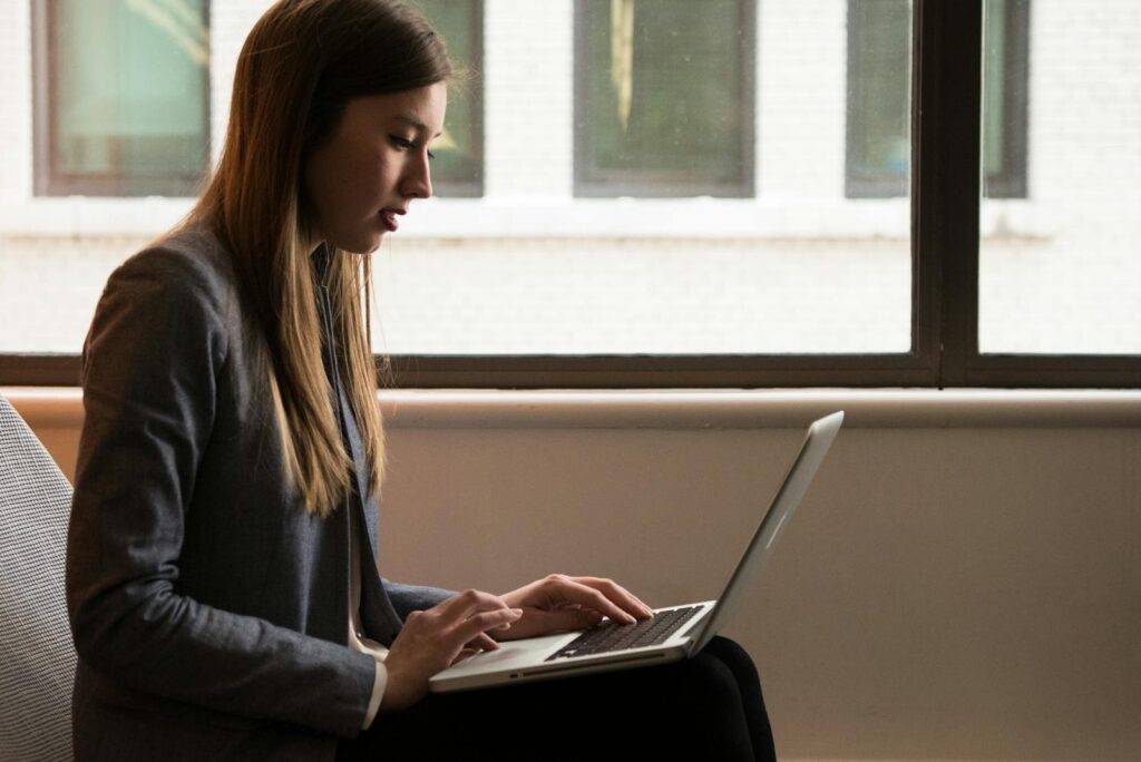 Professional woman using laptop in modern indoor setting. Ideal for business or technology themes.
