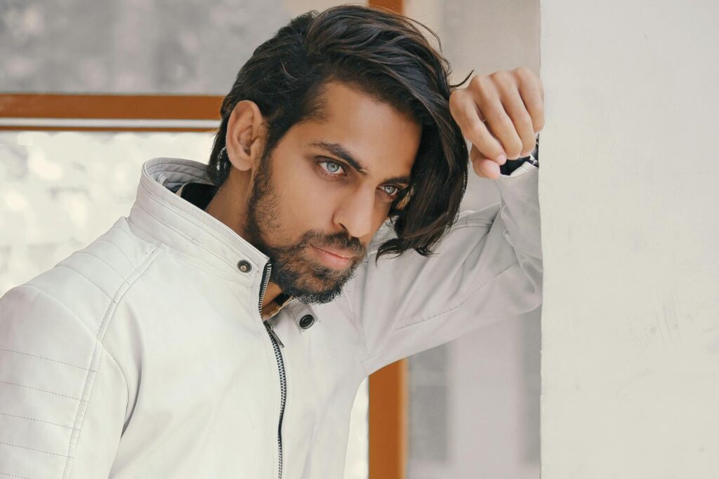 Close-up of a stylish man with long hair and beard indoors in Mumbai.