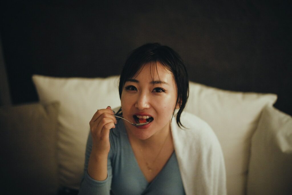 a person sitting on a bed talking on the phone