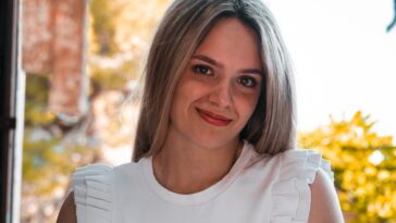 a woman in a white top is posing for a picture