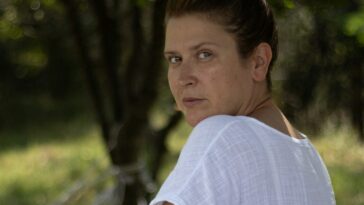 a woman sitting in a hammock in a park
