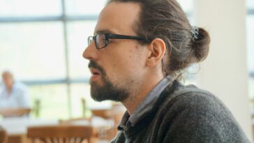 man in black framed eyeglasses and gray hoodie