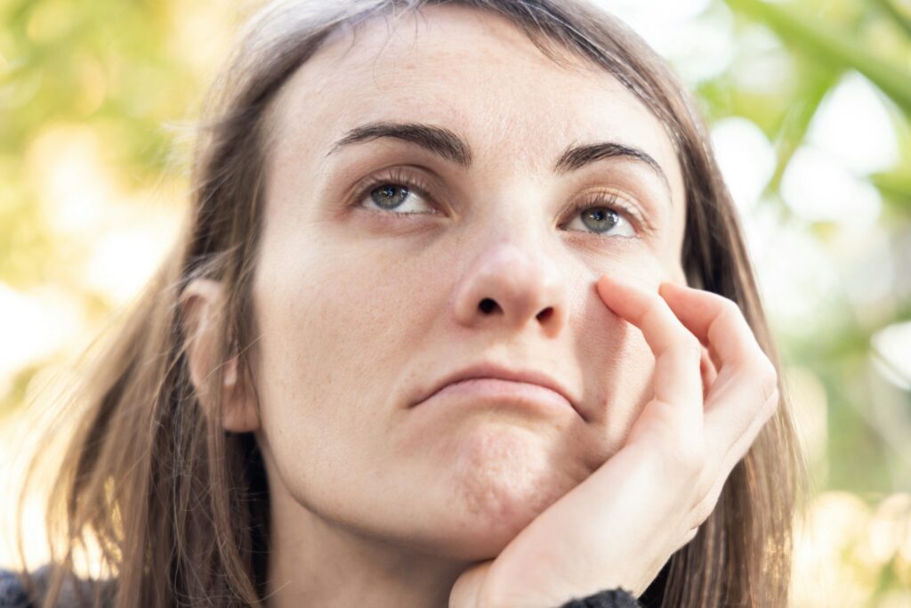 a close up of a person with a hand on their face