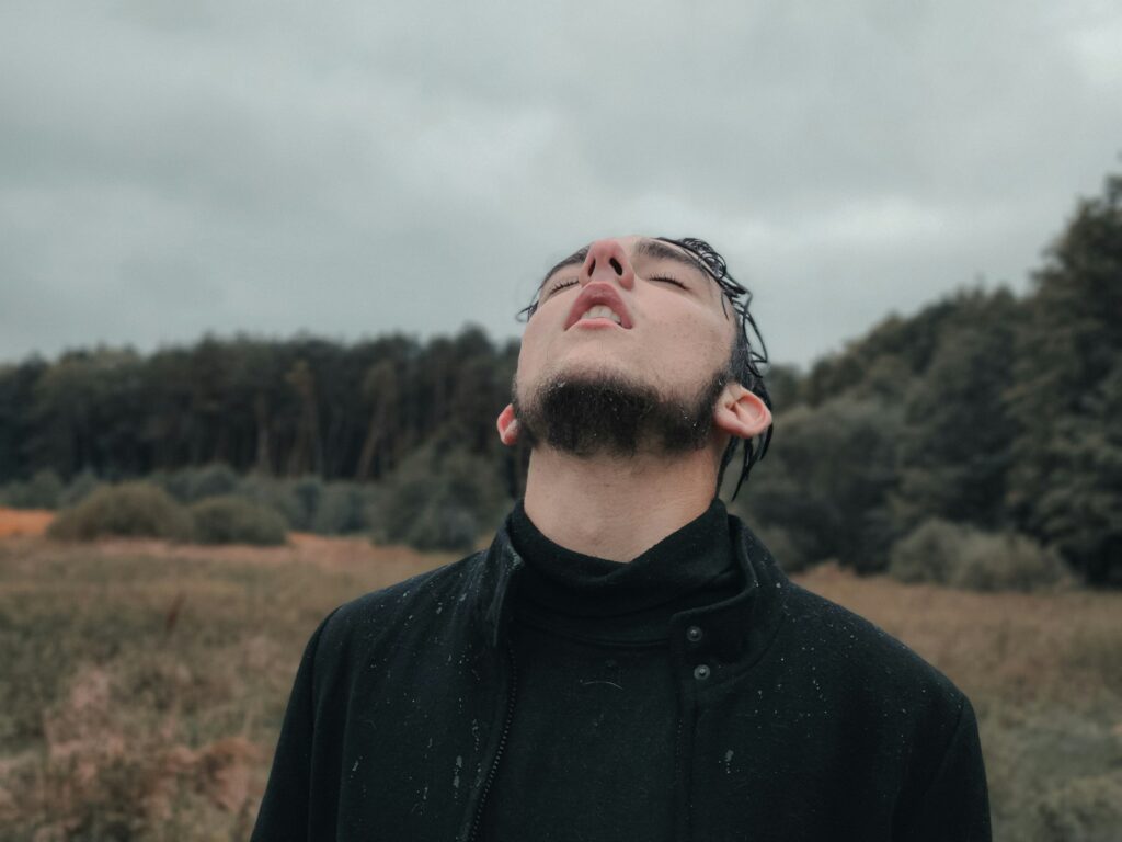 a man standing in a field with trees in the background